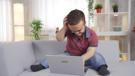 Young-man-with-dwarfism-works-online-from-home-on-laptop.